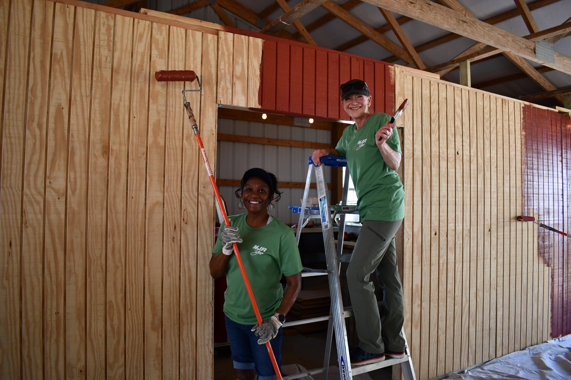 From left, Shandra Chisholm of New Jersey Natural Gas and Amy Cradic of New Jersey Resources paint the walls in the pavilion at Allaire Community Farm.