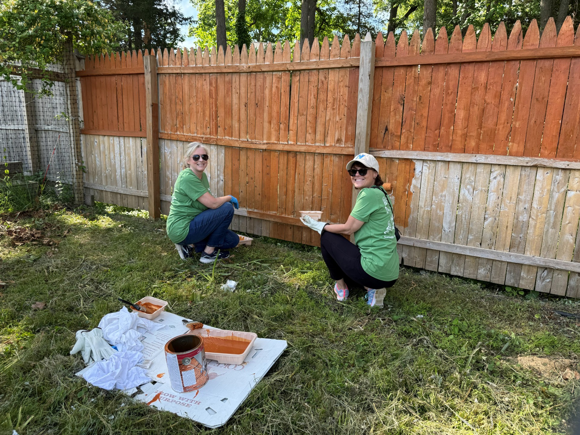Laura McCarthy and Deborah Springsteen of New Jersey Resources paint the fence along Carryville at Allaire Community Farm.