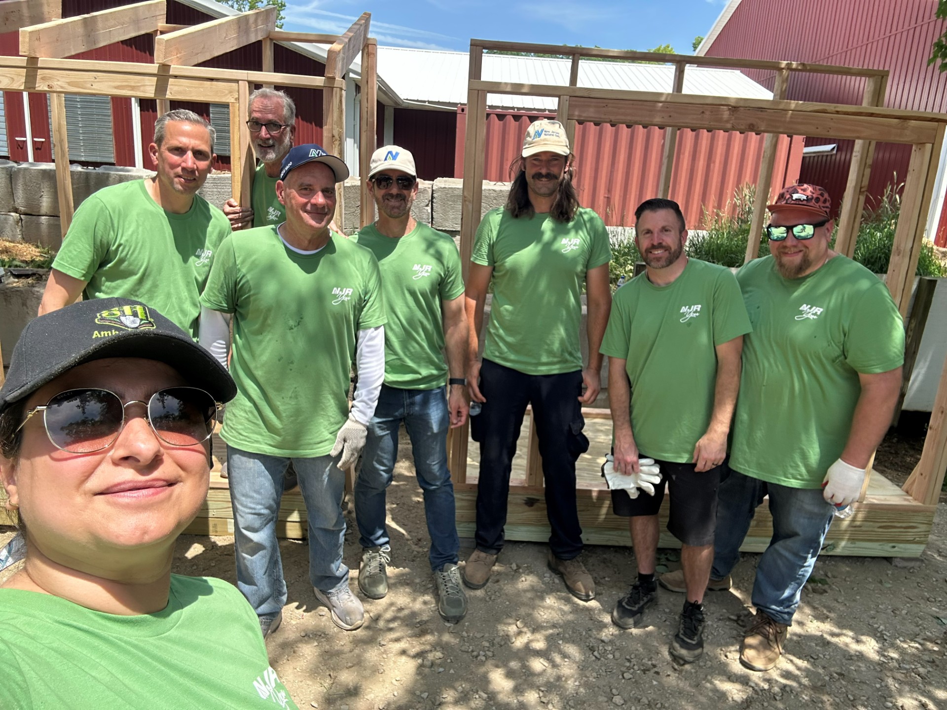 From left, Duaa Muttar, Stephen Skrocki, Randy Smith, Frank Casey, Roberto Bel, Bill Budesa, Andrew Deiudicibus of New Jersey Resources construct new feed and storage sheds at Allaire Community Farm.